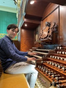 Steven Knieriem sitzt an der Orgel, Hände auf der Tastatur.